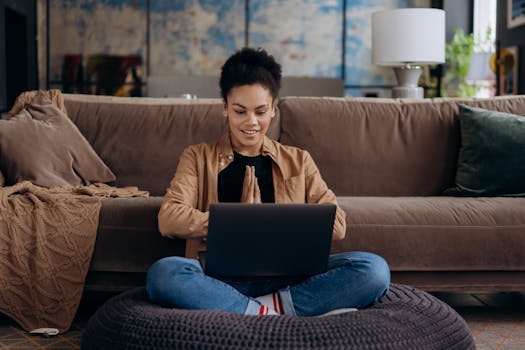 a smiling woman sitting at a desk with a notebook