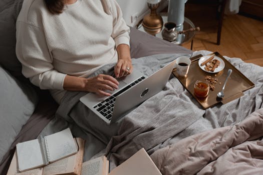 person writing in a notebook with a cup of coffee